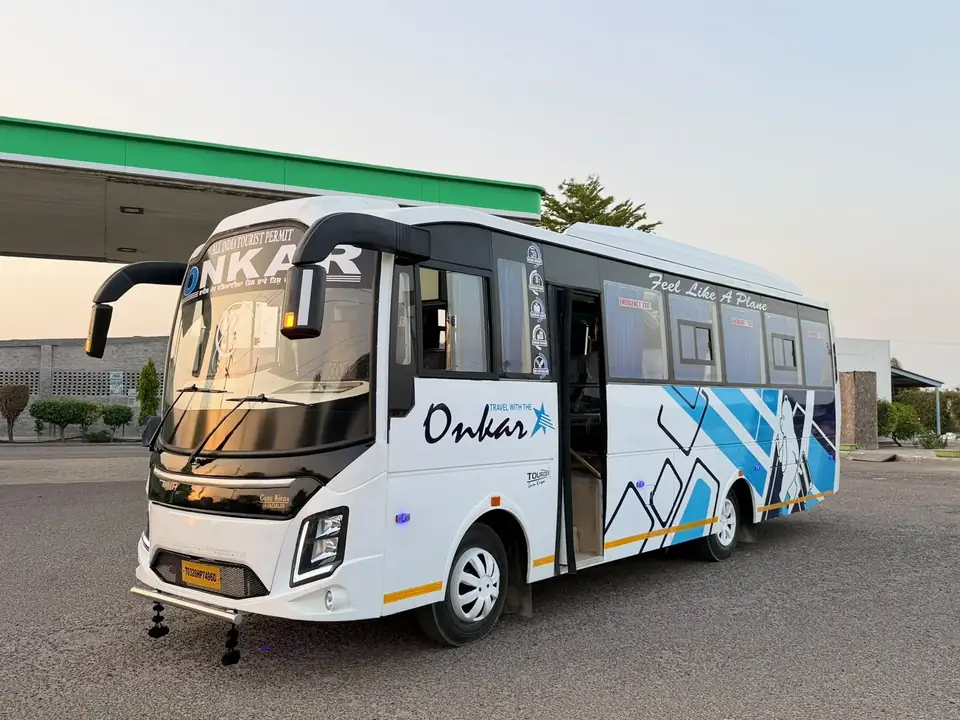 Volvo-type AC deluxe coach, white and blue livery, front three-quarter view — built by Guru Kirpa Bus Body Builders, Barnala